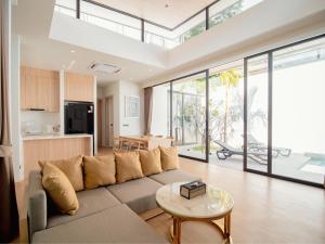 a living room with a couch and a table at Villa Kauri 3BR Pool Villa at Aileen Naithon in Ban Sakhu