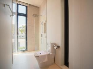 a white bathroom with a toilet and a window at Villa Kauri 3BR Pool Villa at Aileen Naithon in Ban Sakhu +25 photos
