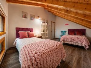 a bedroom with two beds with pink blankets at Casa de las Flores in Panguipulli