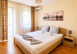 a bedroom with a large bed with white sheets at City Apartments in Sofia