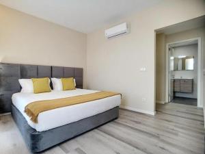 a bedroom with a large bed with yellow pillows at Gaivota Guest House in Ponta Delgada +47 photos