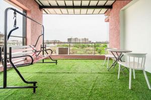 a balcony with a bench and a table with grass at Treebo Arizona in Gandhinagar