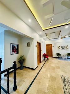 a living room with a table and a red chair at Holiday One Hotel & Suites - Gulshan-4 in Karachi
