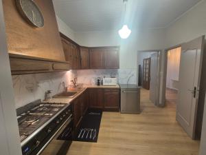 a kitchen with wooden cabinets and a stove top oven at L'Ostal De Papi in Saint-Affrique