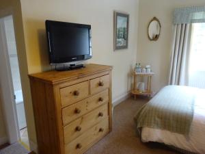 a television on top of a dresser in a bedroom at Elibank House B&B in Walkerburn