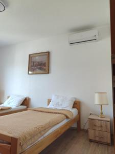 a bedroom with two beds and a lamp on a table at Pansion Ajlin in Blagaj