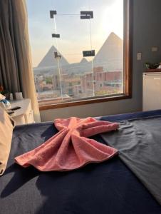 ein Handtuch auf einem Bett vor einem Fenster in der Unterkunft فندق مونتو - Montu pYramids Hotel in Kairo