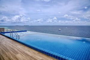 a swimming pool with a view of the ocean at Triton Exotica in Maafushi