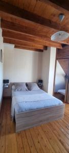 a bedroom with a large bed with a wooden floor at Duplex le Randonneur - Les Apparts du Sancy in Chastreix