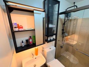 a bathroom with a toilet and a sink and a shower at Penthouse Nook - Ananda square in Manila