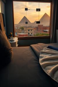 ein Schlafzimmer mit Blick auf die Pyramiden aus einem Fenster in der Unterkunft فندق مونتو - Montu pYramids Hotel in Kairo