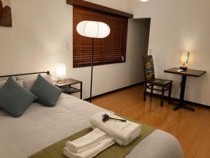 a bedroom with a bed with towels and a chair at HOUSE26 Private Villa near Green Expo Yokohama in Machida