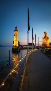 a lighthouse with lights on the water at night at Gästehaus Jasmin in Lindau +36 photos