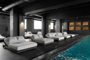 a room with a row of beds next to a swimming pool at ETERNA HOTEL & SPA by Fomich in Palyanytsya