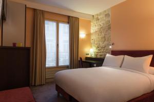 パリにあるホテル ダネマークのベッドルーム(大きな白いベッド1台、窓付)