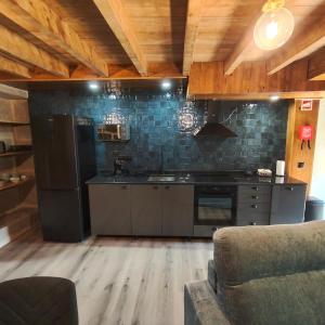 a kitchen with a black refrigerator and a stove at Casa Fornos de Amor in Fornos de Algodres