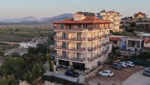 a large building with cars parked in front of it at Golden Berden Boutique Apart-Hotel in Sarandë