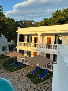 a building with chairs and umbrellas next to a pool at M&H Boutique Hotel in Mombasa
