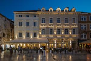 a large building with people standing in front of it at Heritage hotel Santa Lucia in Split