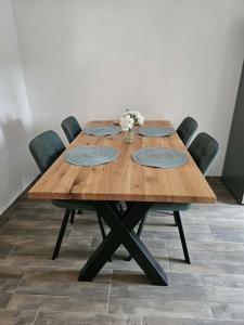 a wooden table with four chairs around it at Apartmán v klubu in Staré Sedlo
