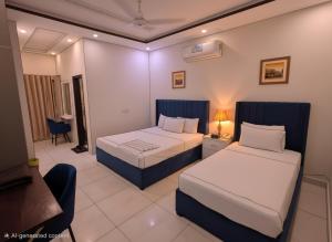 a hotel room with two beds and a chair at Cuzzy Inn Stay in Lahore +55 photos