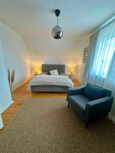 a bedroom with a bed and a blue chair at Geräumige Wohnfühloase mit 3 Schlafzimmern in Garbsen