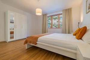 a white bedroom with a large bed and a window at Pure living Apartment in Zürich Oerlikon in Zurich