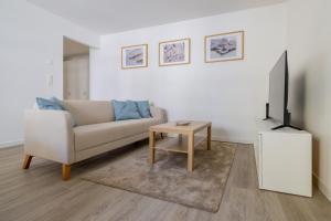 a living room with a couch and a tv and a table at Pure living Apartment in Zürich Oerlikon in Zurich
