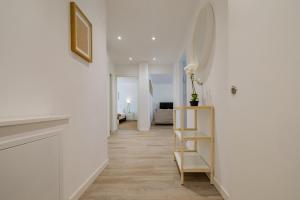a hallway with white walls and a mirror on the wall at Pure living Apartment in Zürich Oerlikon in Zurich +10 photos