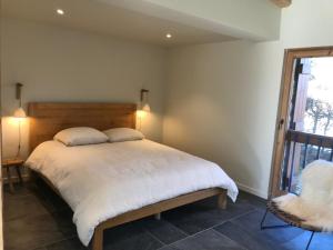 a bedroom with a bed and a chair and a window at LE REFUGE DE LUCE in Saint-Gervais-les-Bains