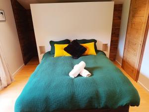 a bedroom with a green bed with two towels at LE REFUGE DE LUCE in Saint-Gervais-les-Bains