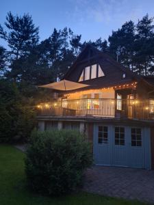 a large house with a porch and a deck at night at Przystanek Kaszuby in Kamień