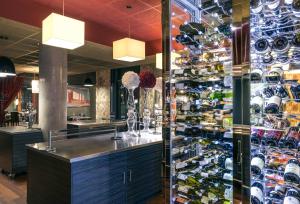Mercure Lyon Centre - Gare Part Dieu في ليون: بار في مطعم يحتوي على جدار من زجاجات النبيذ