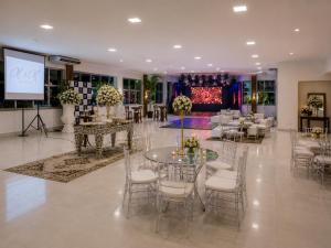 a banquet hall with tables and chairs and a screen at Granterrara Hotel in Jequié +40 photos