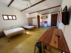 a room with a table and a couch and a wooden table at Pousada Fanticelli in Nova Viçosa