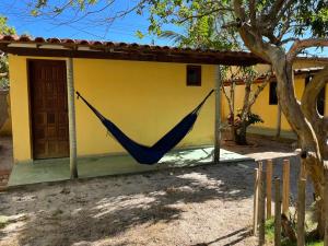 a hammock hanging from the side of a house at Pousada Fanticelli in Nova Viçosa