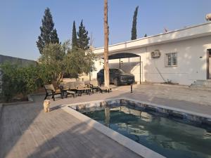 a dog standing next to a swimming pool next to a house at Domaine salma in Maherine