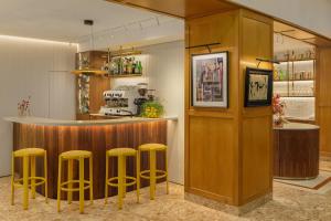eine Bar mit vier gelben Hockern in einem Raum in der Unterkunft Hotel Duran in Figueres