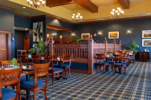a restaurant with wooden tables and blue chairs at Rodd Crowbush Golf & Beach Resort in Morell