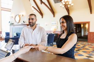 a man and a woman shaking hands at a desk at Rodd Crowbush Golf & Beach Resort in Morell +66 photos