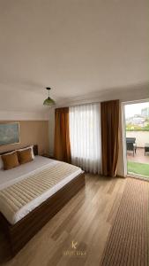a bedroom with a large bed and a large window at Hotel Kika in Prishtinë