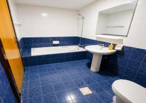 a bathroom with a tub and a sink and a toilet at TIDY Premium Hostel, Sharjah in Sharjah
