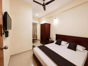 a bedroom with a bed and a flat screen tv at BKR Resort in Kuttālam