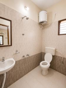 a bathroom with a toilet and a sink at BKR Resort in Kuttālam