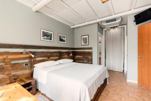 a bedroom with a white bed and a tv at Ca'Luna Guest House in Mondovì