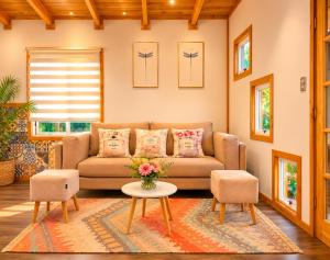 a living room with a couch and two chairs at Tiny house in Coñaripe
