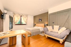 a bedroom with a bed and a table and a couch at Ca'Luna Guest House in Mondovì