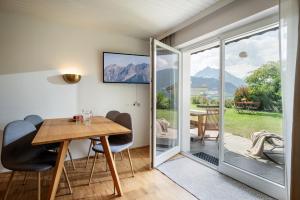 a dining room with a table and chairs and a sliding glass door at Ferienwohnungen Tiroler Alpenhof in Innsbruck +50 photos
