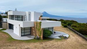 a white house with a view of the ocean at Cantinho das Buganvilias AT**** in Queimada