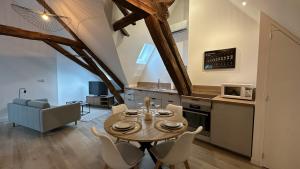 a kitchen and dining room with a table and chairs at L'ombrelle in Chablis